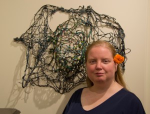 Curator Crystal Edwards with her piece "Galaxy" made from painted yarn.
